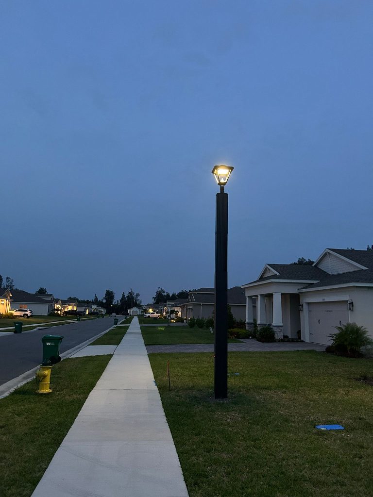 SolarPath decorative solar post-top light along a residential sidewalk at dusk in Armen Groves