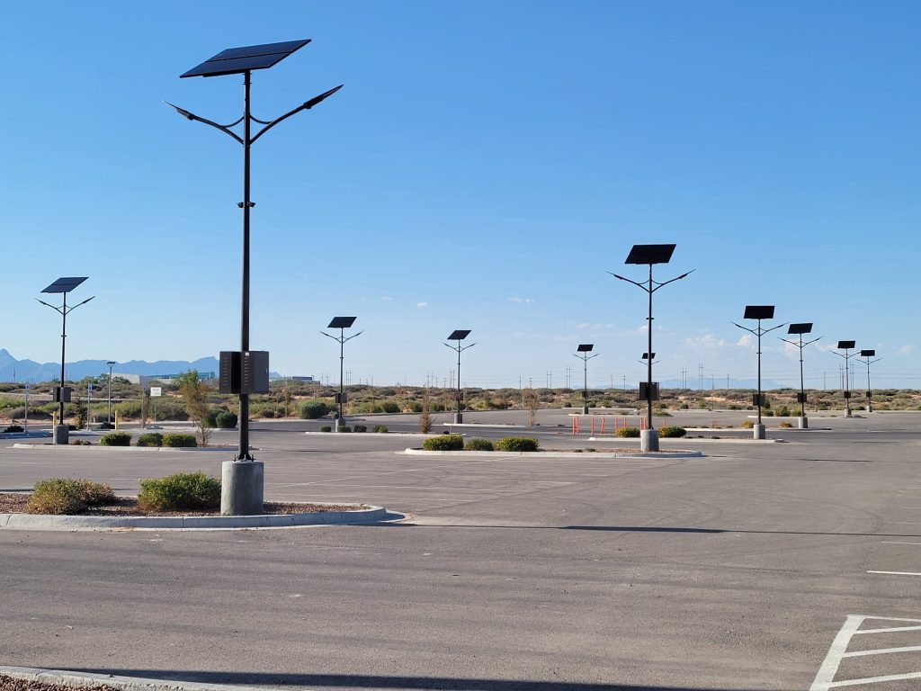 Array of SolarPath dual-arm solar parking lot lights with mountain backdrop