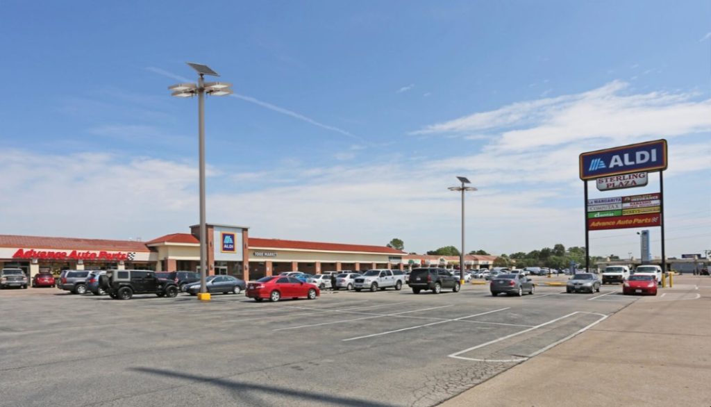 SolarPath dual-panel solar area lights over a retail plaza parking lot